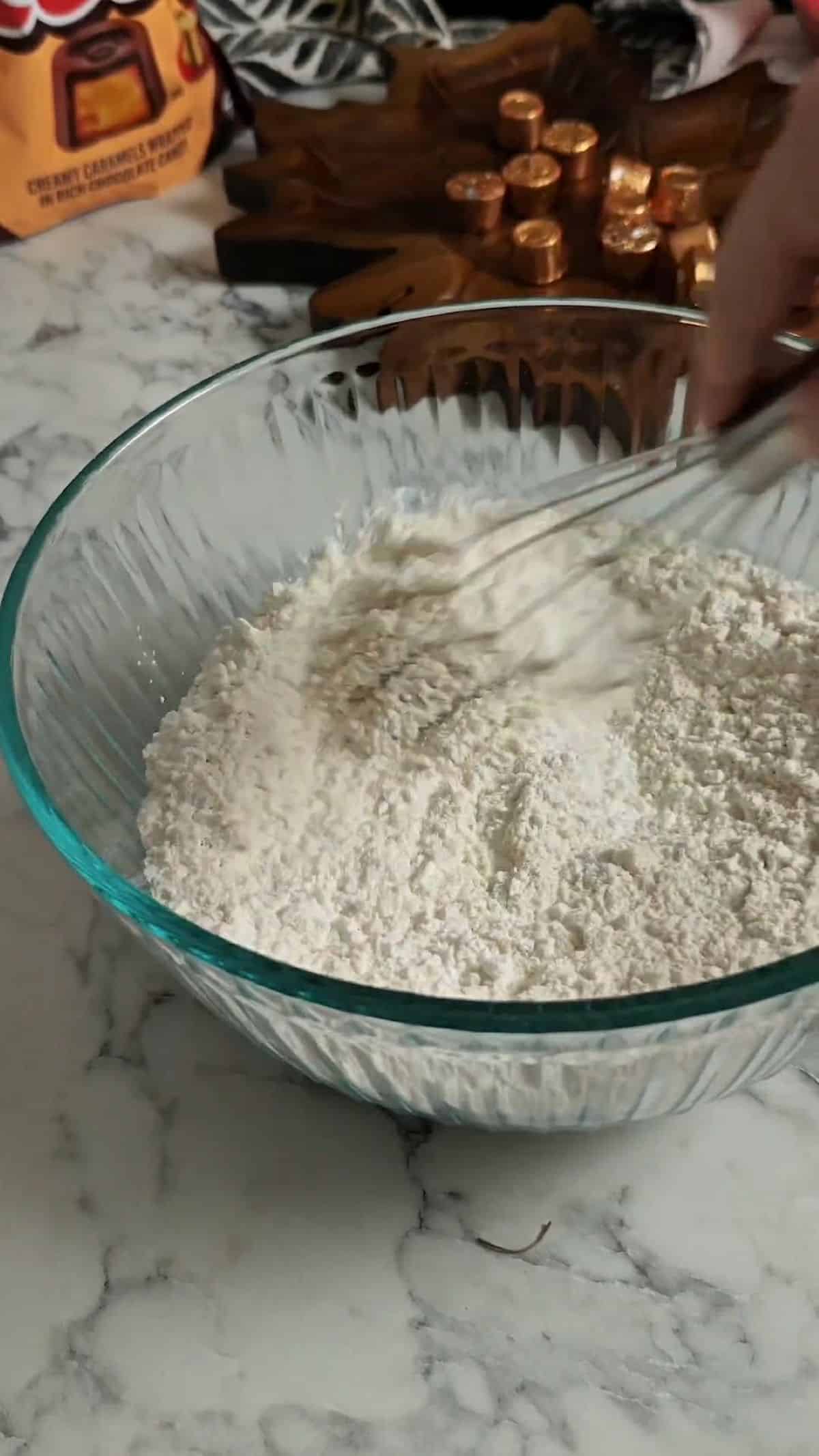 Dry ingredients in a glass bowl for cookies.